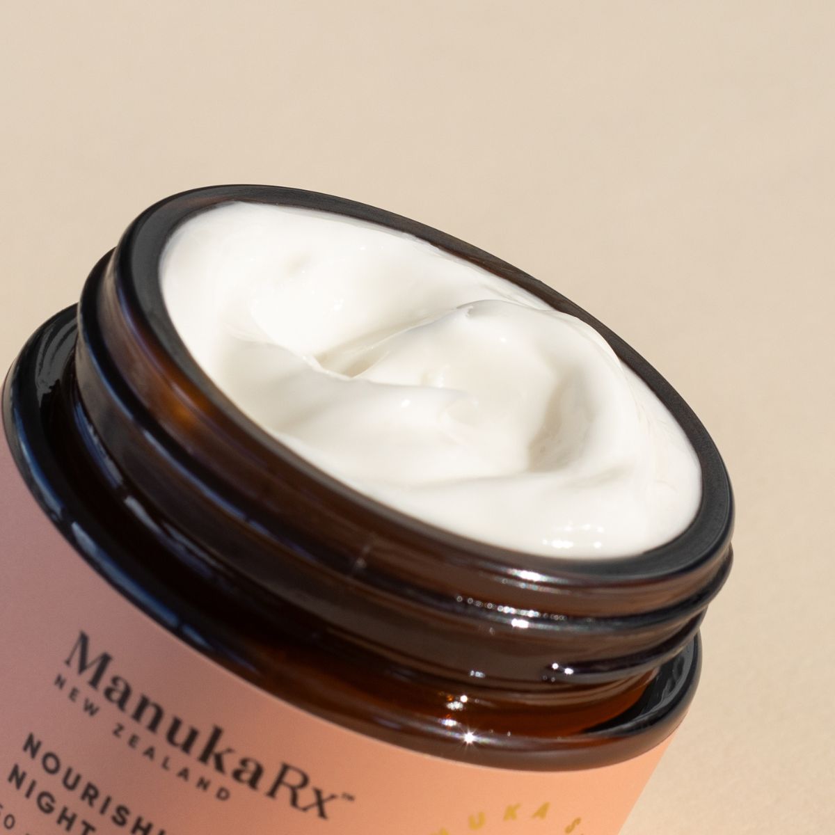 A detailed close-up image of ManukaRx's Nourishing Night Cream open jar