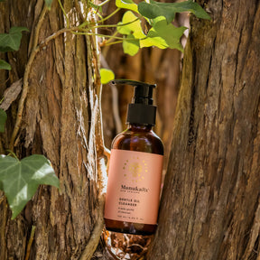 Bottle of ManukaRx Gentle Oil Cleanser sitting in a tree