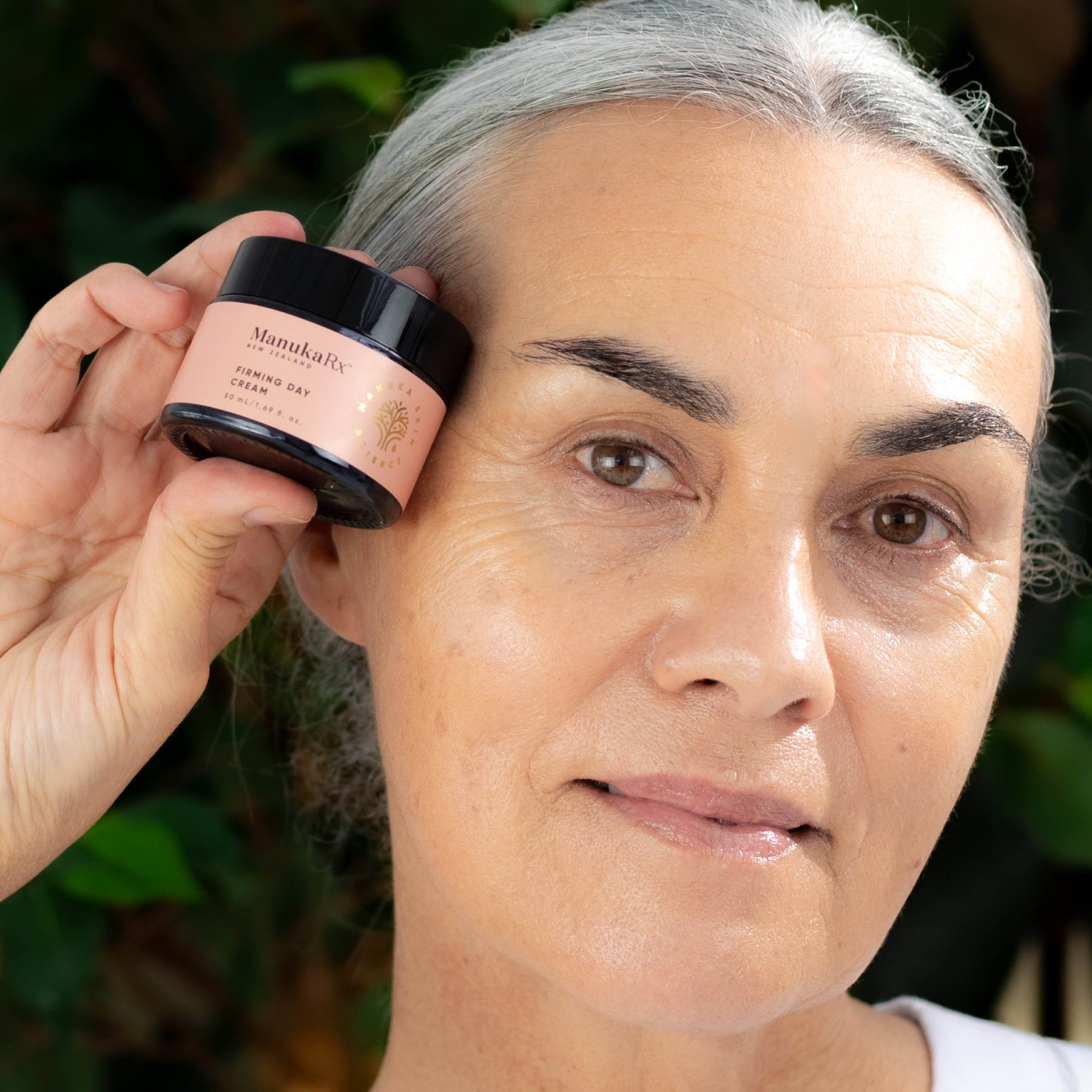 Woman holding jar of ManukaRx Firming Day Cream